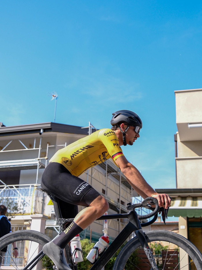 Atleta in maglia gialla di leader in azione durante una gara su strada