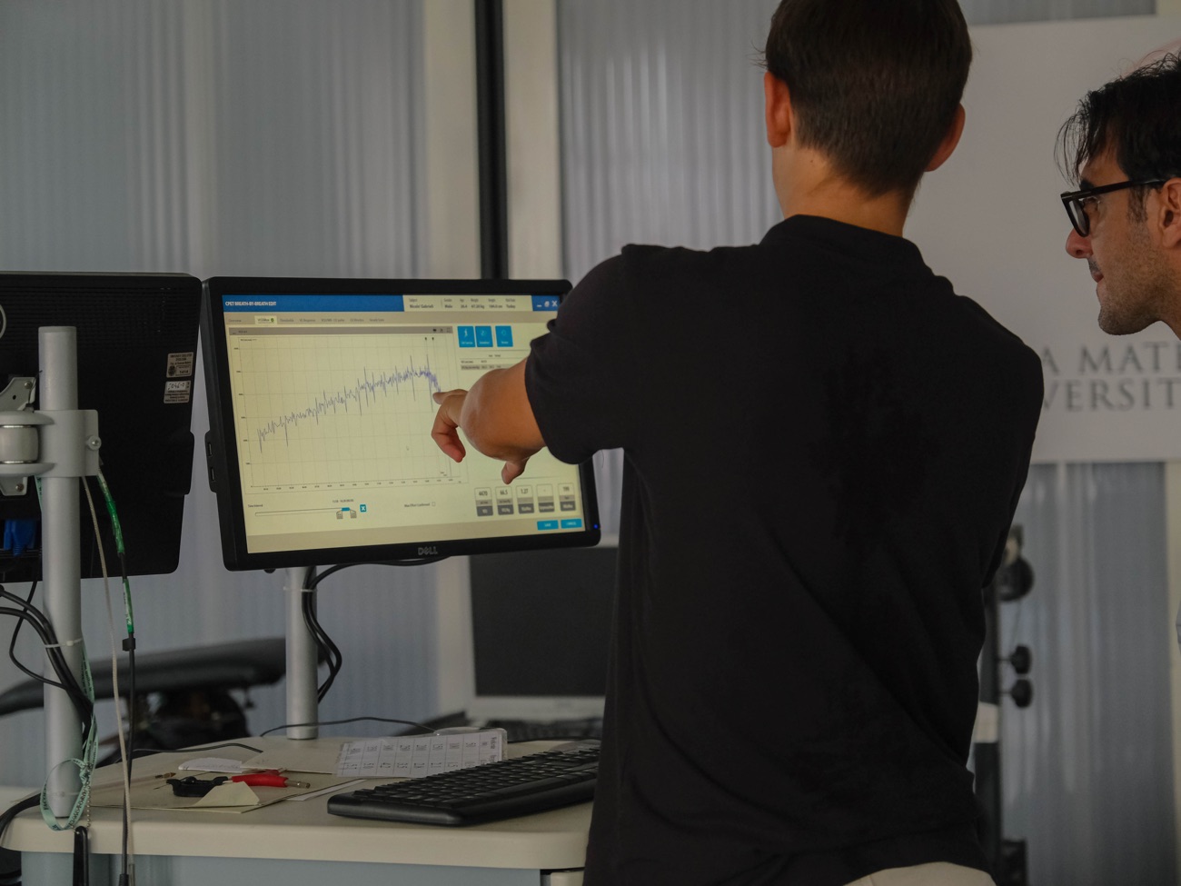 Il coach spiega all'atleta le curve del test sul monitor della postazione di analisi