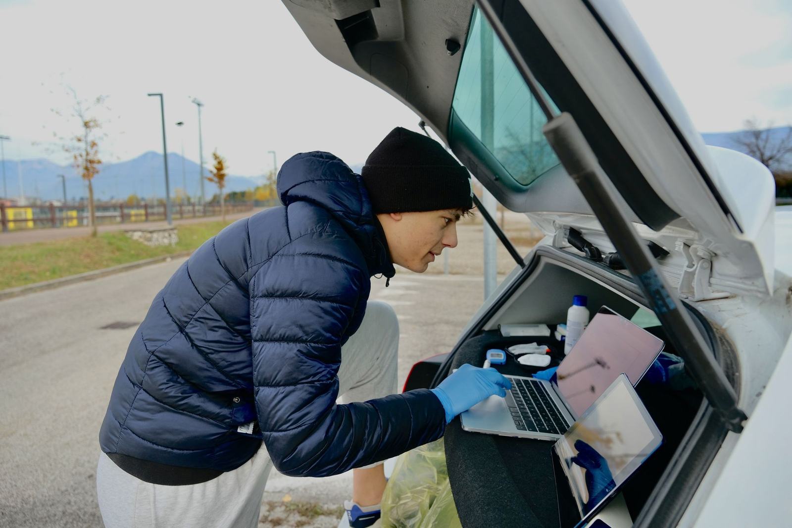 Lorenzo Elipanni prepara il test sul campo dal bagagliaio dell'auto, con laptop e analizzatore